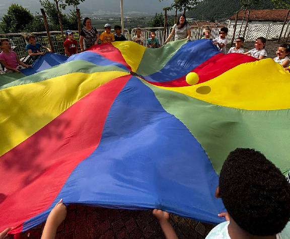 studenti e maestre che reggono un grande telo colorato