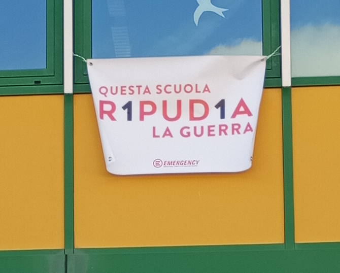 Foto dell'ingresso della scuola il manifesto della Campagna R1PUD1A "Questa scuola ripudia la guerra"