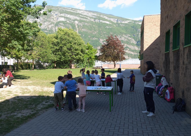 Foto con bambini che realizzano laboratorio attorno ad un tavolo