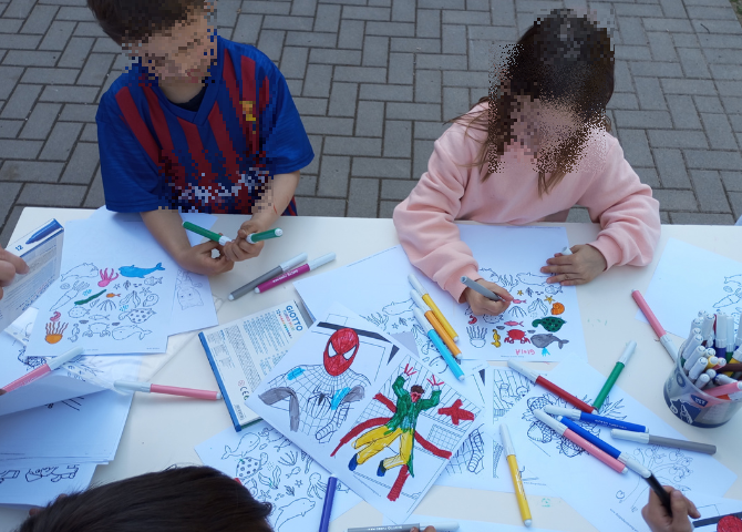 Foto con bambini che realizzano laboratorio attorno ad un tavolo