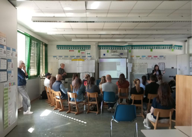Foto con genitori che ascoltano l'esperta in un'aula