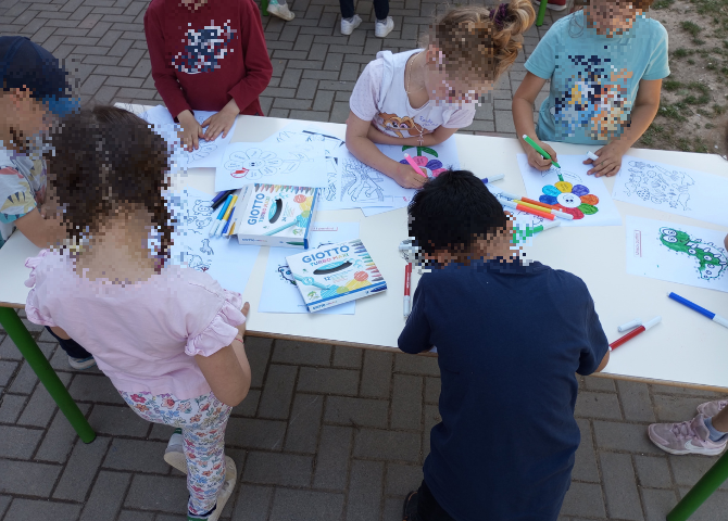 Foto con bambini che realizzano laboratorio attorno ad un tavolo